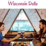 a pin with a couples having a toast at one of the most romantic cabins in Wisconsin Dells