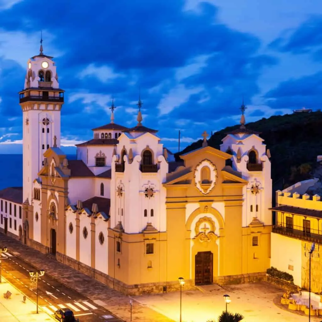 blue sky with during the night with white clouds and a view of Candelaria Church on night lighted by yellow lights