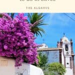 Pin with image of a white stone church with ornate embellishments and a bell tower and crucifixes on top with some vibrant purple and green flowers and shrubberies in the foreground, caption reads: Wonderful Things to do in Silves, The Algarve from Paulina on the Road