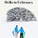 Pin with image of two people in colorful winter clothing walking across a wide open area covered thickly in snow towards a group of green trees dusted in white snow, caption reads: Amazing Things to do in Wisconsin Dells in February from paulinaontheroad.com