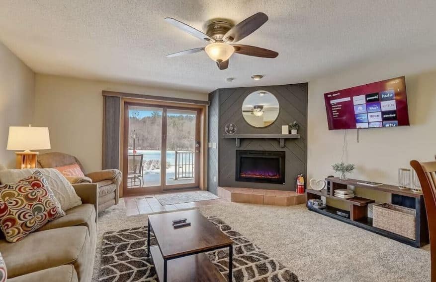cozy living room with fire place, sofa and TV at Sunset Cove 303 · Steph's Waterfront Retreat in Wisconsin Dells