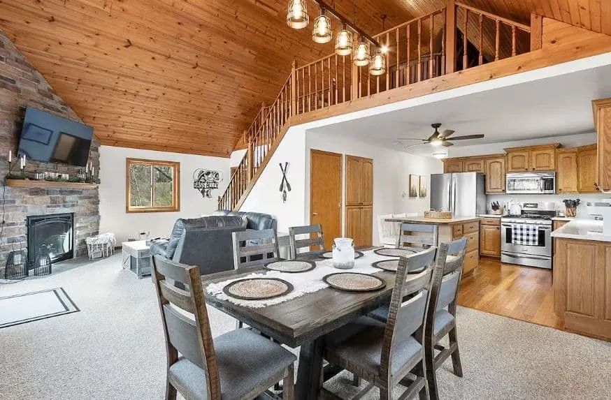 interior of a house with kitchen, living room space, fire place and staircase at the Relaxing Cabin close to Cascade Mountain & Wisconsin Dells