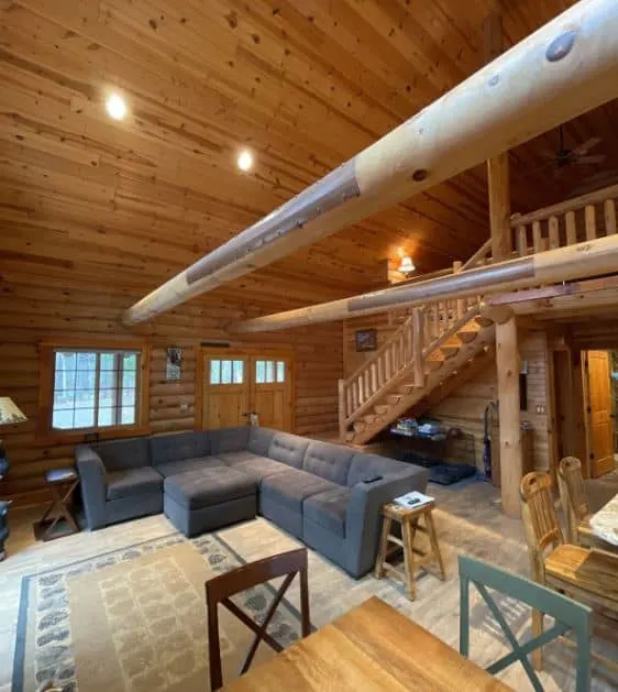 living room area with open space kitchen and staircase at the Log cabin secluded on 80 acres in Arpin, Wisconsin