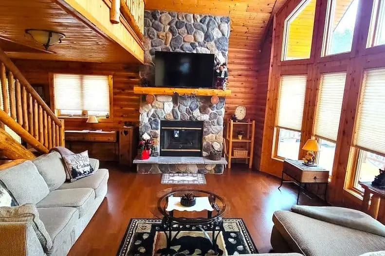 wooden living room with fire place and sofa at the Home Sweet Log in Wisconsin Dells