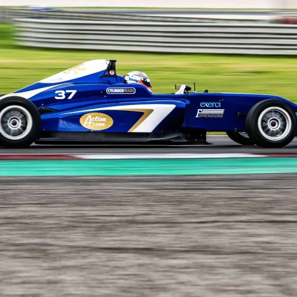 Blue race car driving fast in circuit lane