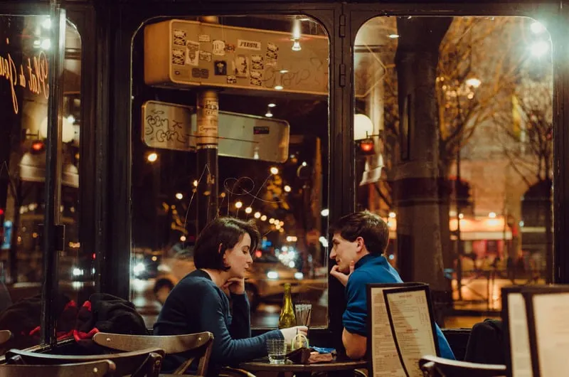 Man and woman sitting in chair inside restaurant during nighttime