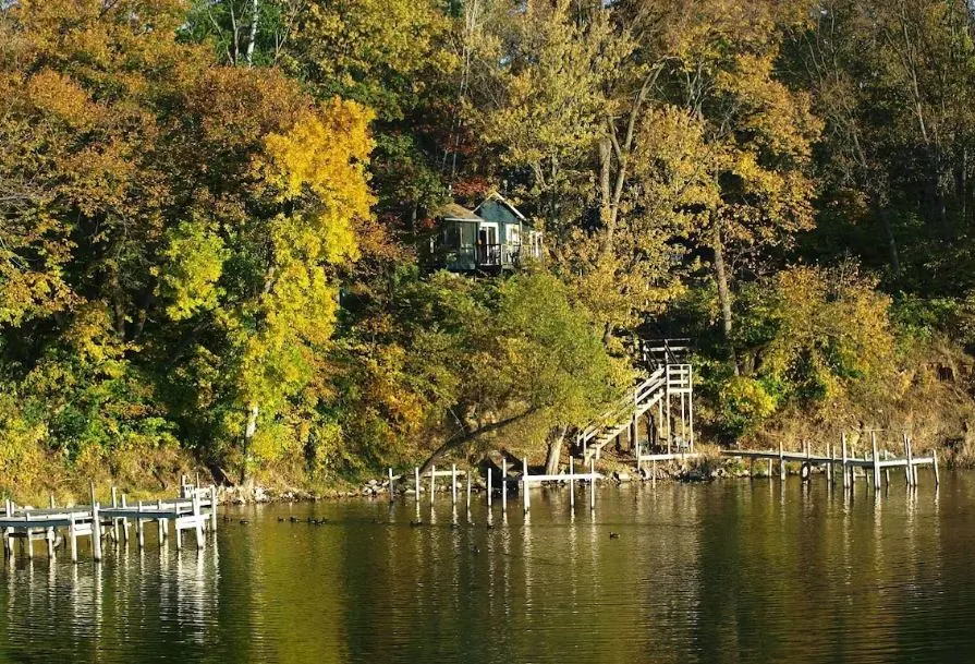 Private cabin in Koshn area in Edgerton, Wisconsin seen from the water and surrounded by forest