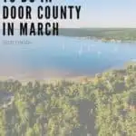 Pin with aerial shot of white sailing boats floating in a harbor between banks covered in thick green forest all under a wide open blue sky with a few wispy white clouds, caption reads: Fun Things to Do in Door County in March, Wisconsin from paulinaontheroad.com