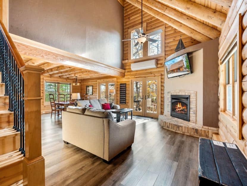 cozy wooden living room with sofa, dining area and fire place at Log cabin with firepit in Sister Bay