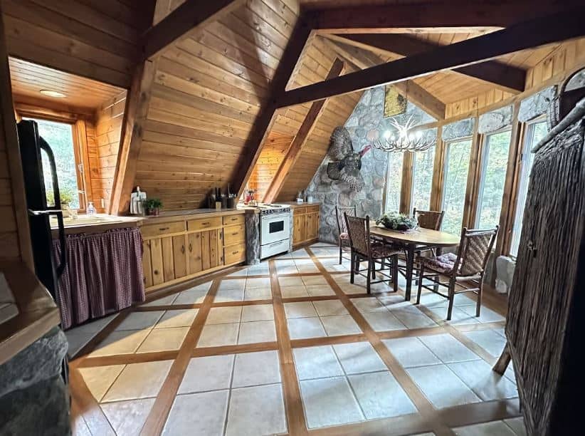 kitchen area with dining table and big windows at Beautiful Chalet on Lake Metonga in Crandon, Wisconsin