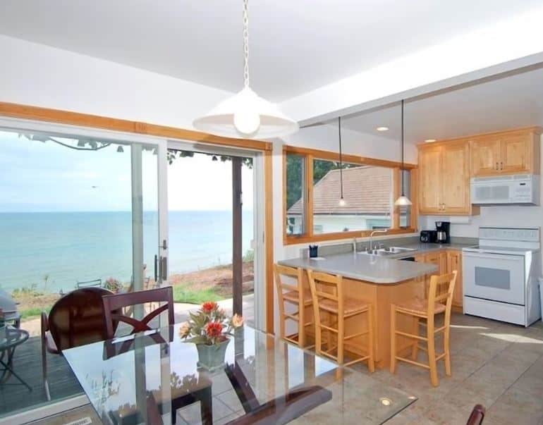 kitchen with dining table and balcony with lake view at the Cozy Lake Michigan Cottage in Sheboygan, Wisconsin