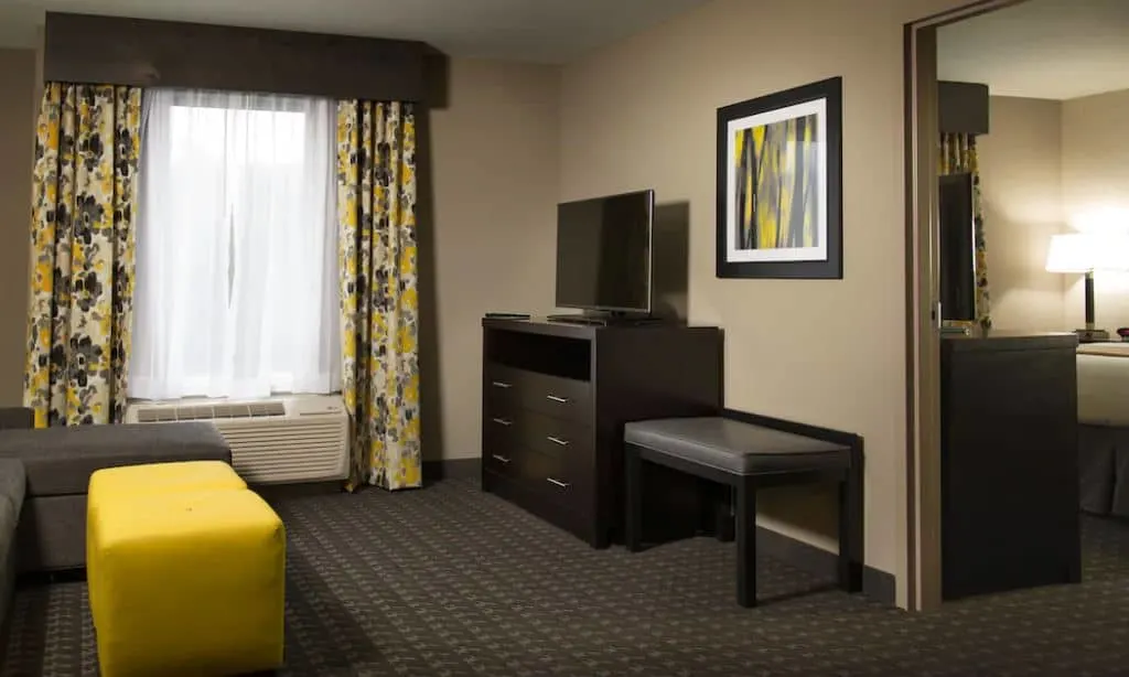 living room with sofa and TV next to a bedroom at Holiday Inn Express & Suites Madison Central, an IHG Hotel, Wisconsin