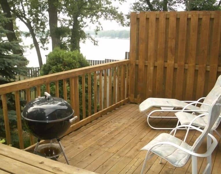 small balcony with grill and lounge chairs at Lake Kegonsa Cottage in Stoughton, Wisconsin