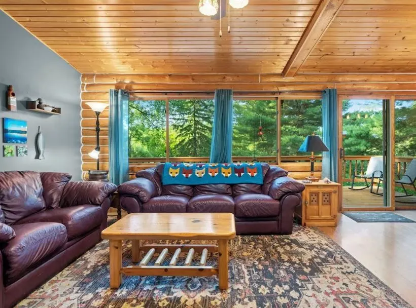 wooden living room with sofa and balcony at one of the best Sister Bay Cabin Rentals