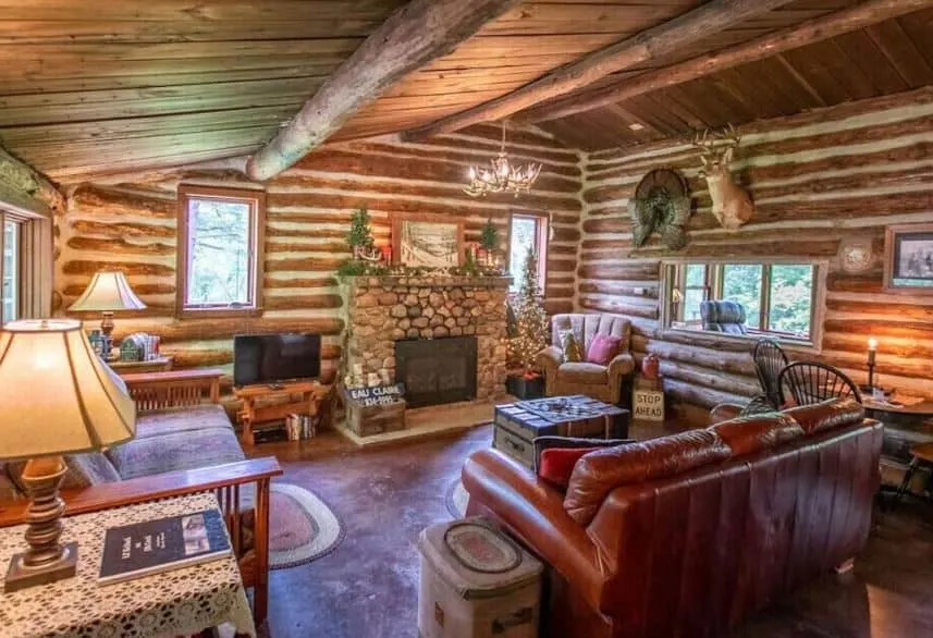 wooden living room with sofa in front of a fire place at Lil’ Kickback On Elk Creek in Elk Mound, Wisconsin