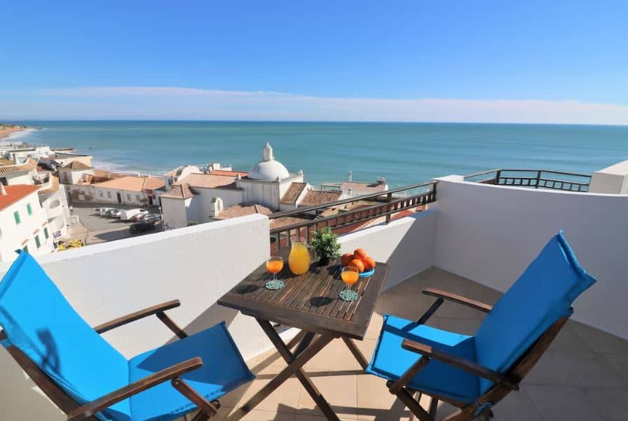 2 chairs and a table on the balcony of the Panoramic Seaview Apartment in Albufeira, Portugal