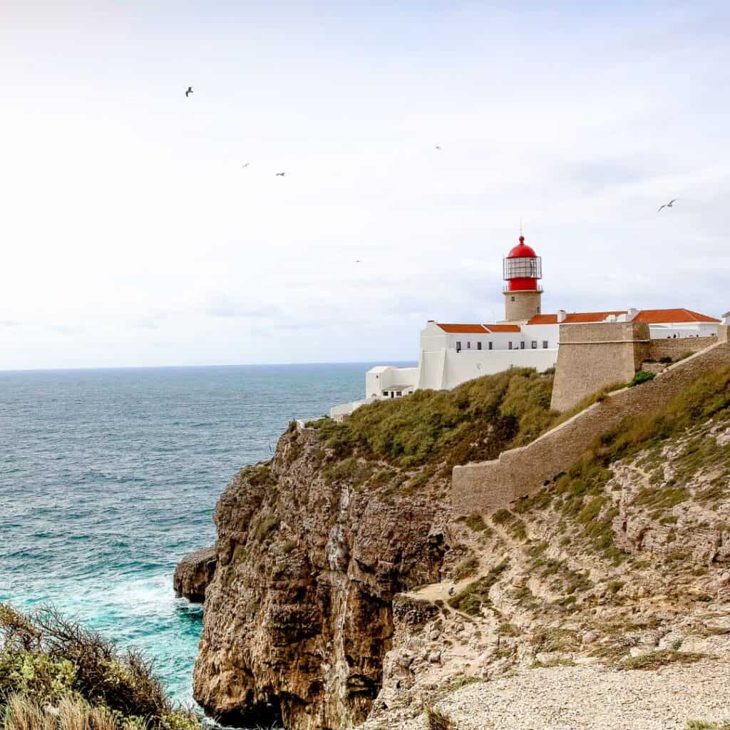 a lighthouse on a cliff overlooking a body of water