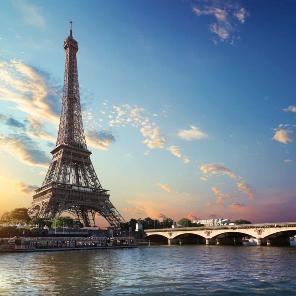 a view of the eiffel tower from a river on a sunset