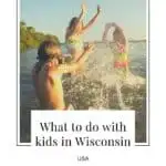 Pin with image of three children playing and splashing water around in a lake with trees behind all under a clear sky at sunset, caption reads: What to do with kids in Wisconsin, USA from paulinaontheroad.com