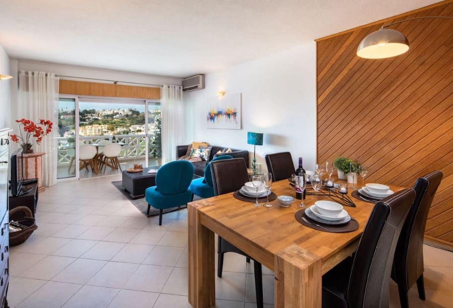 dining room with table, sofa, TV and balcony at Apartment with fantastic sea view in Albufeira, Portugal