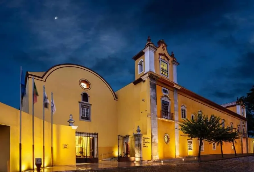 exterior of the Pousada Convento in Tavira, Algarve, Portugal at night with moon in the clouds