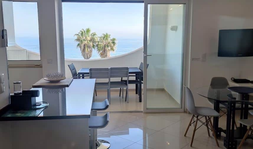 kitchen area with dining table and balcony at the beach apartment in albufeira
