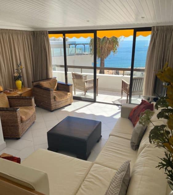 living room with sofa and balcony overlooking the sea at the Seaview apartment at Cerro Branco Albufeira, Portugal
