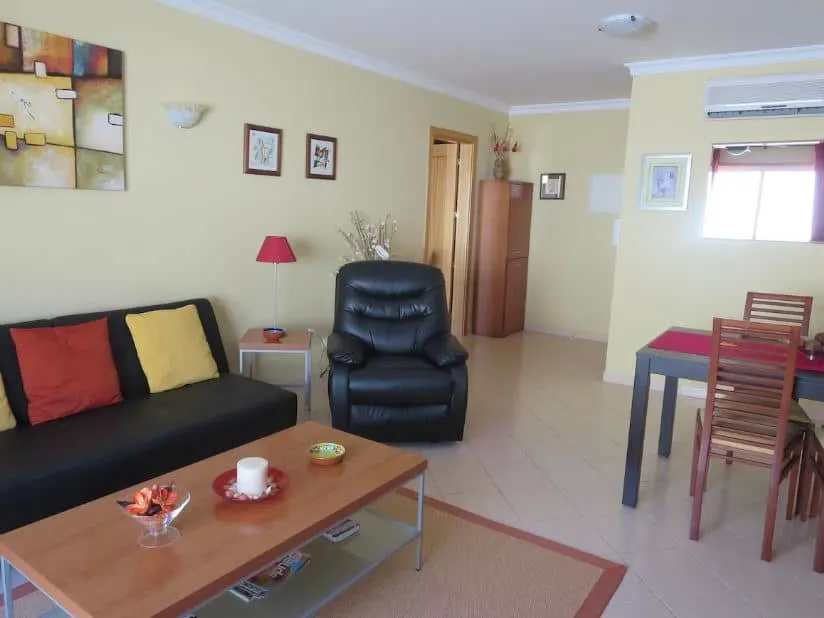 room with sofa arm chair and dining table at Condo in Oldtow Albufeira - Airbnb in Albufeira: 12 Cozy Places to Stay