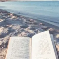 someone reading one of the best books about the sea by the sea