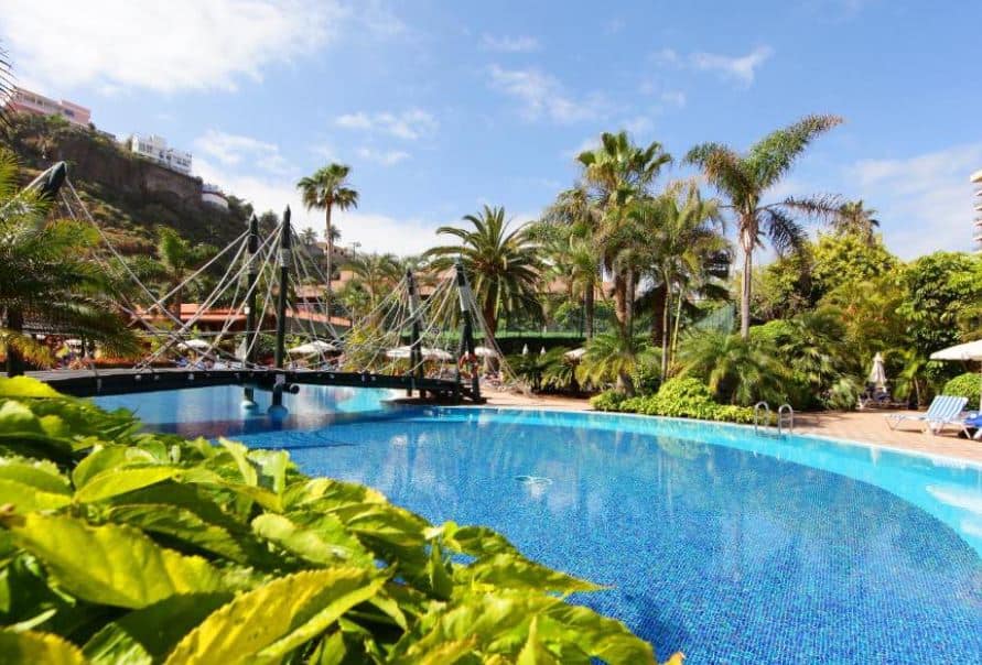 view of the pool with sun lounges and palm trees at Bahia Principe Sunlight San Felipe in Puerto de la Cruz, Tenerife