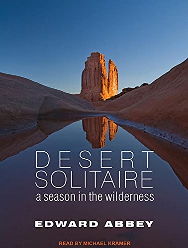 a book cover with a picture of a big rock reflected on the water in the desert