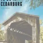 Pin with image of a large covered wooden bridge with an internal hatch of criss-crossing wooden beams standing in the sunshine under a bright blue sky with wispy white clouds, caption reads: Fun Things to Do in Cedarburg, Wisconsin from paulinaontheroad.com