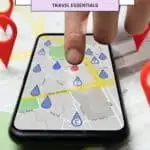a pins drop around a printed google map on a table with a person touching the pins on the phone