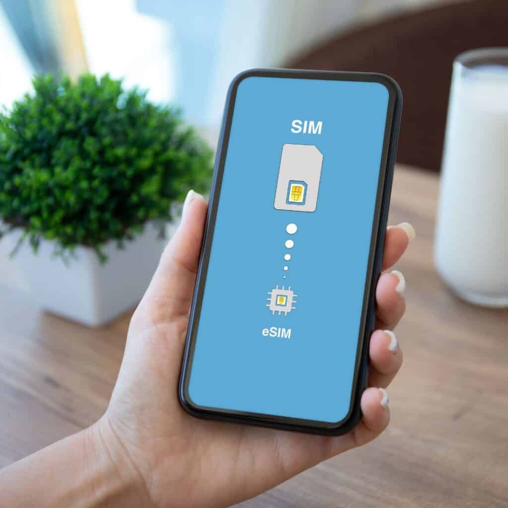 a hand holding a phone with a screen saying sim and esim