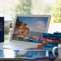 Lonely Planet Coffee Table Books on a table next to a laptop