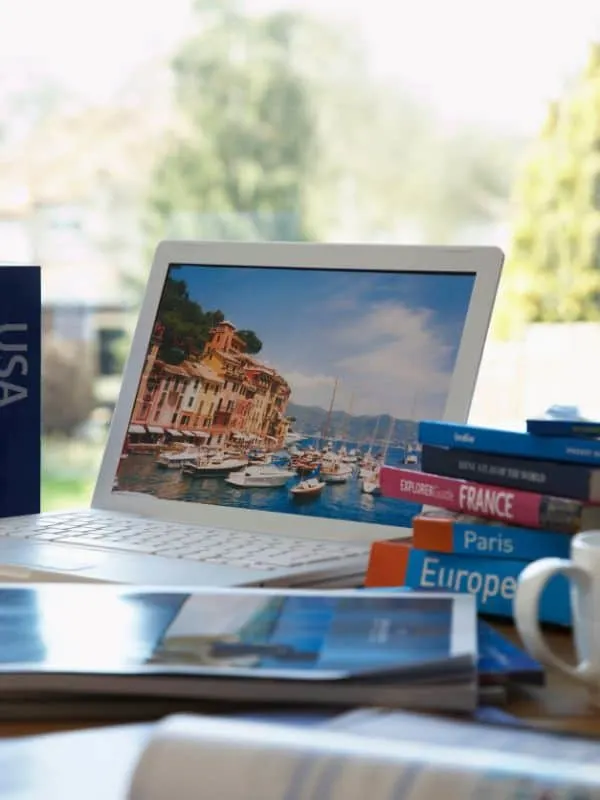 Lonely Planet Coffee Table Books on a table next to a laptop