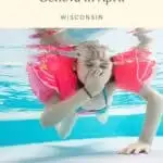 Pin with image of a young child in a bathing suit and red water wings holding their breath underwater in a swimming pool, caption reads: Best Things to Do in Lake Geneva in April, Wisconsin from Paulina on the Road