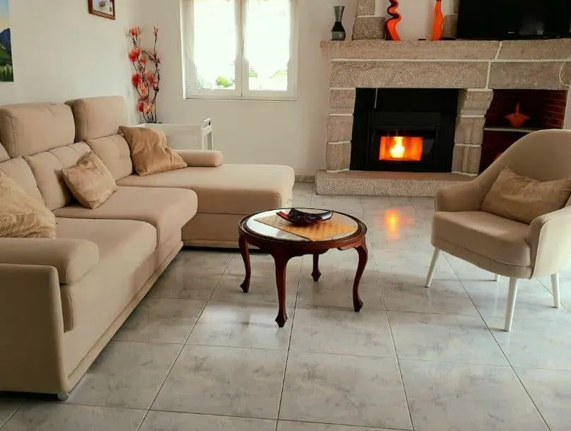 fireplace in a living room with sofa at Charming villa in the heart of a typical and picturesque village - Marinhas, Esposende