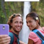 a pinterest pin about how to avoid roaming charges showing a photo of a man and woman taking a selfie with a waterfall