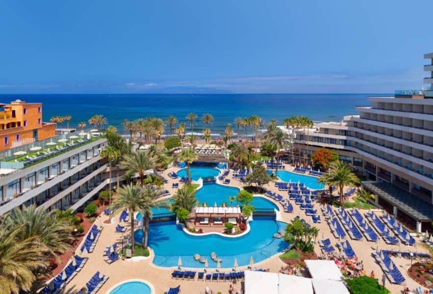 view from above of the pool area with sun lounges and sea view at H10 Conquistador, Tenerife