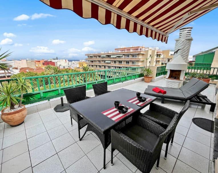 balcony with table and chairs, sun lounges and bbq at the Sunny Penthouse in Tenerife