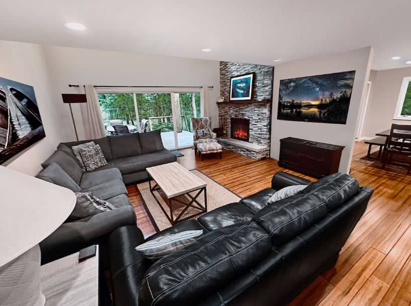 black sofas in a living room with fire place at Relaxing Waterfront, Spacious Home - Baileys Harbor