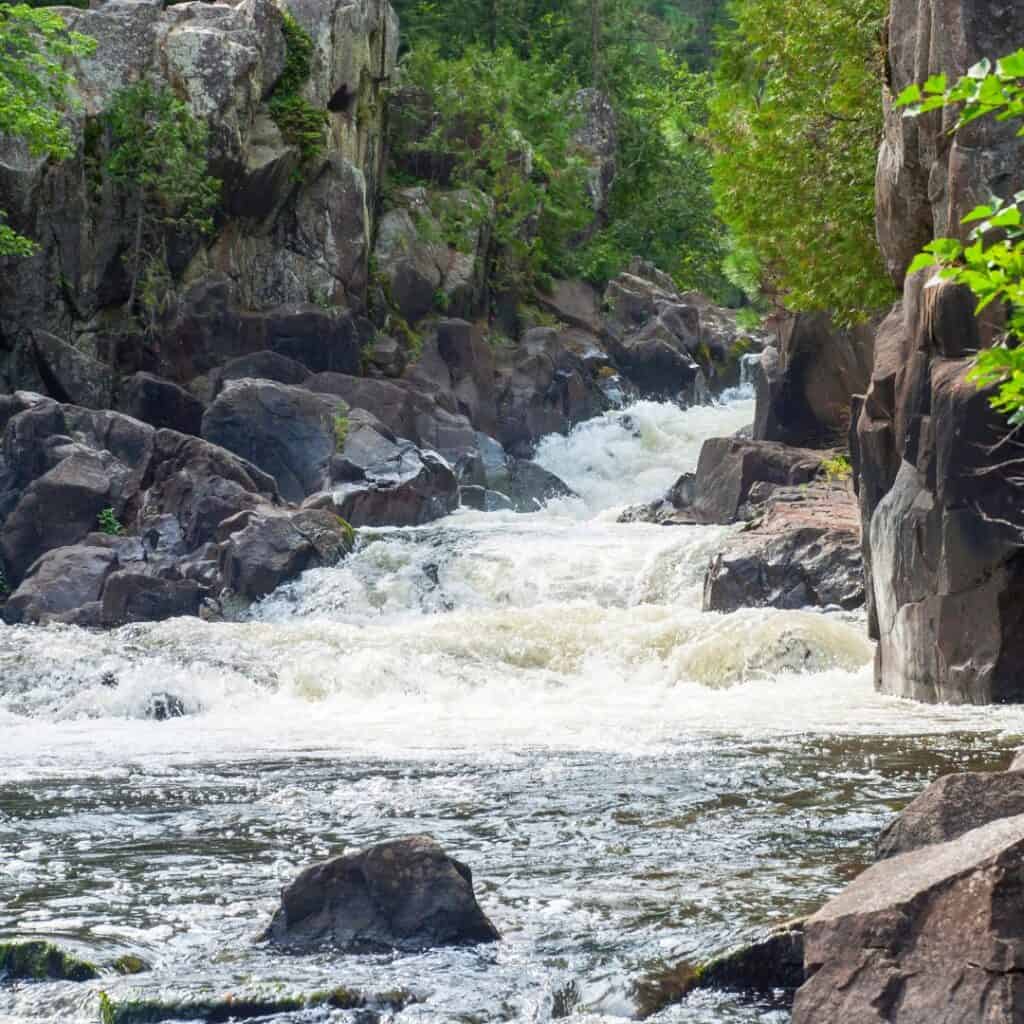 gushing water flowing from dave's falls in wisconsin surrounded by large rocky formations