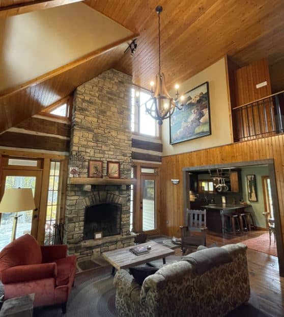 living room with fireplace, sofa and high ceiling at the Cabin With Modern Kitchen, Fireplace, Porch - Fish Creek