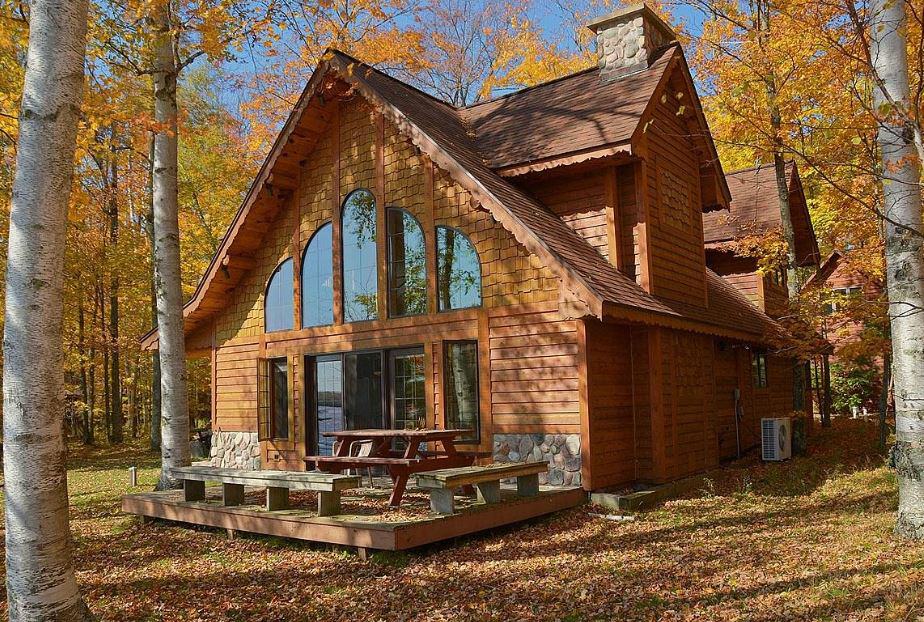 log cabin with patio and surrounded by forest at Staudemeyer's Four Seasons Resort in Cable