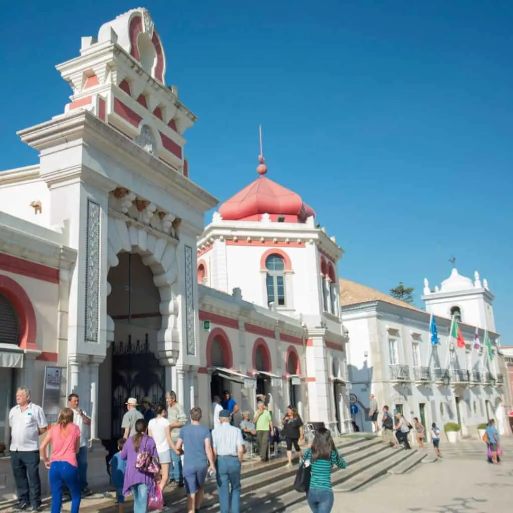 people hanging around outside the markethall in the town of loule algarve portugal