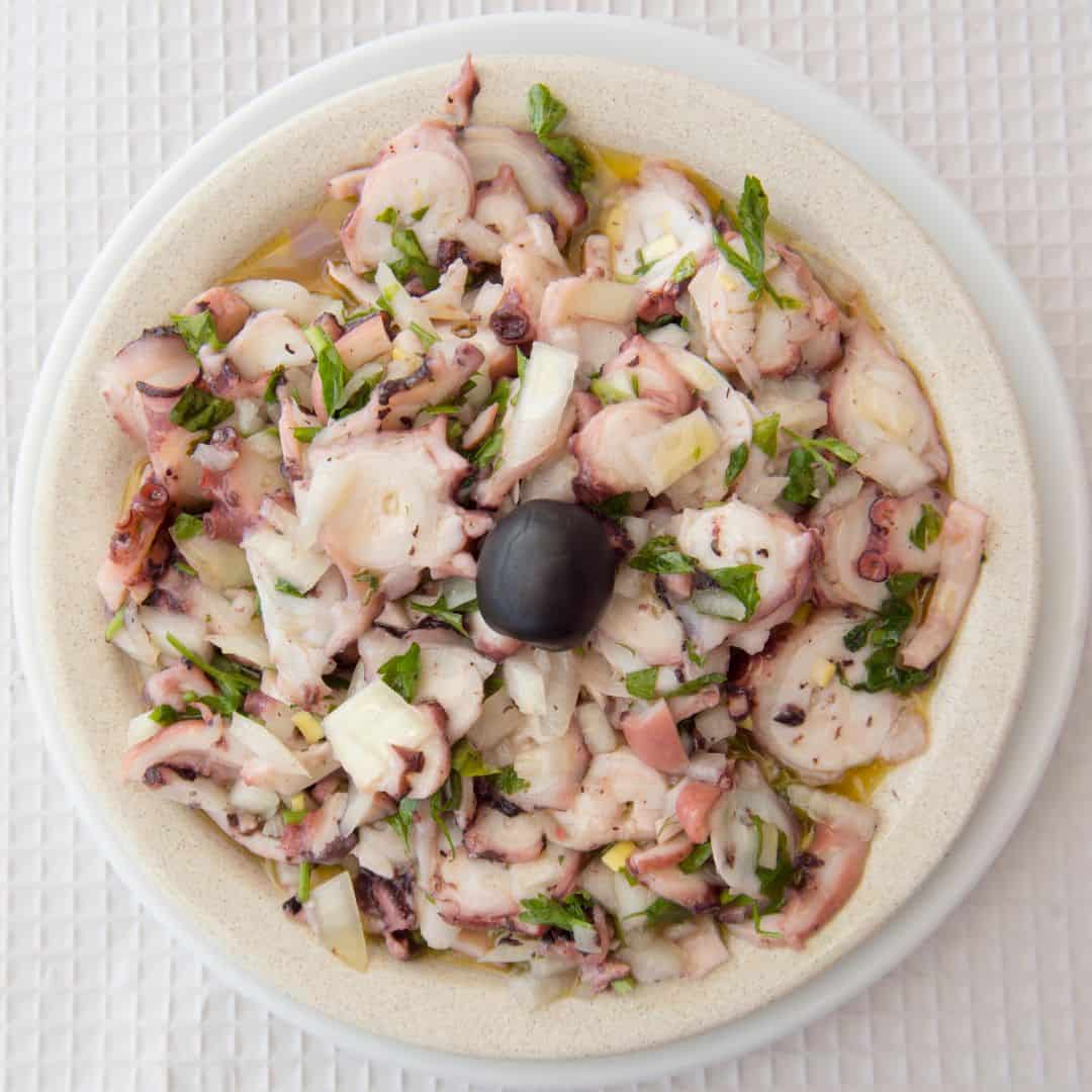 octopus salad served in a white plate, traditional algarvian cuisine
