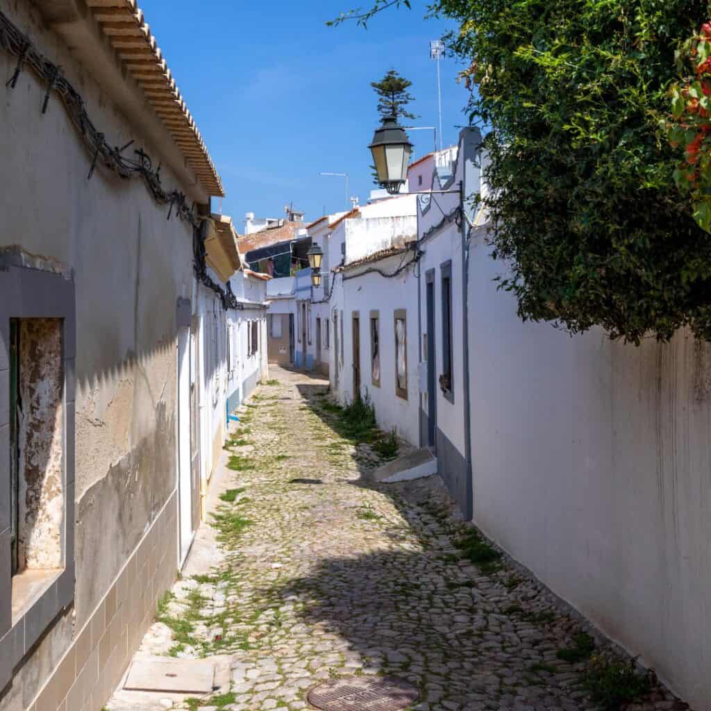 small road with traditional houses in loule, algarve portugal