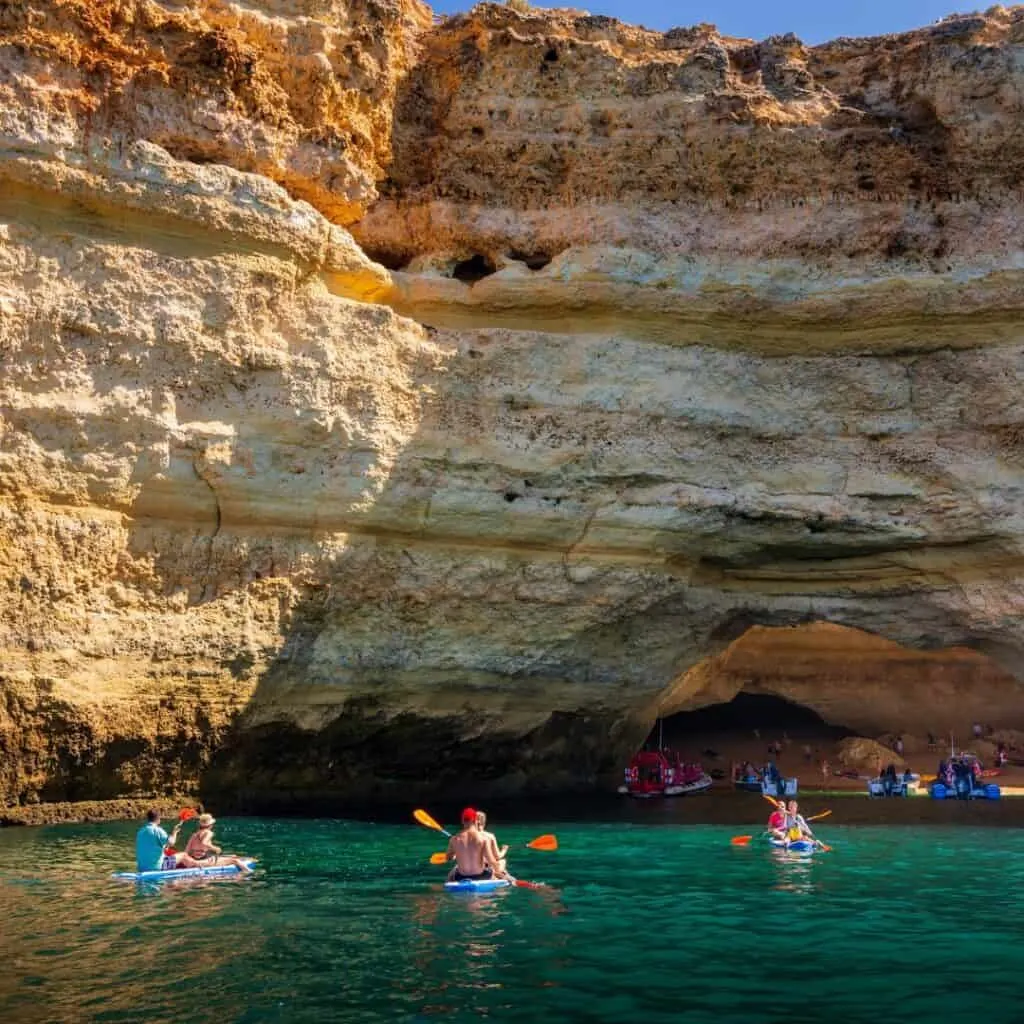 People kayaking towards Benagil Cave, a famous sea cave in Portugal known for its stunning natural formations and breathtaking beauty.