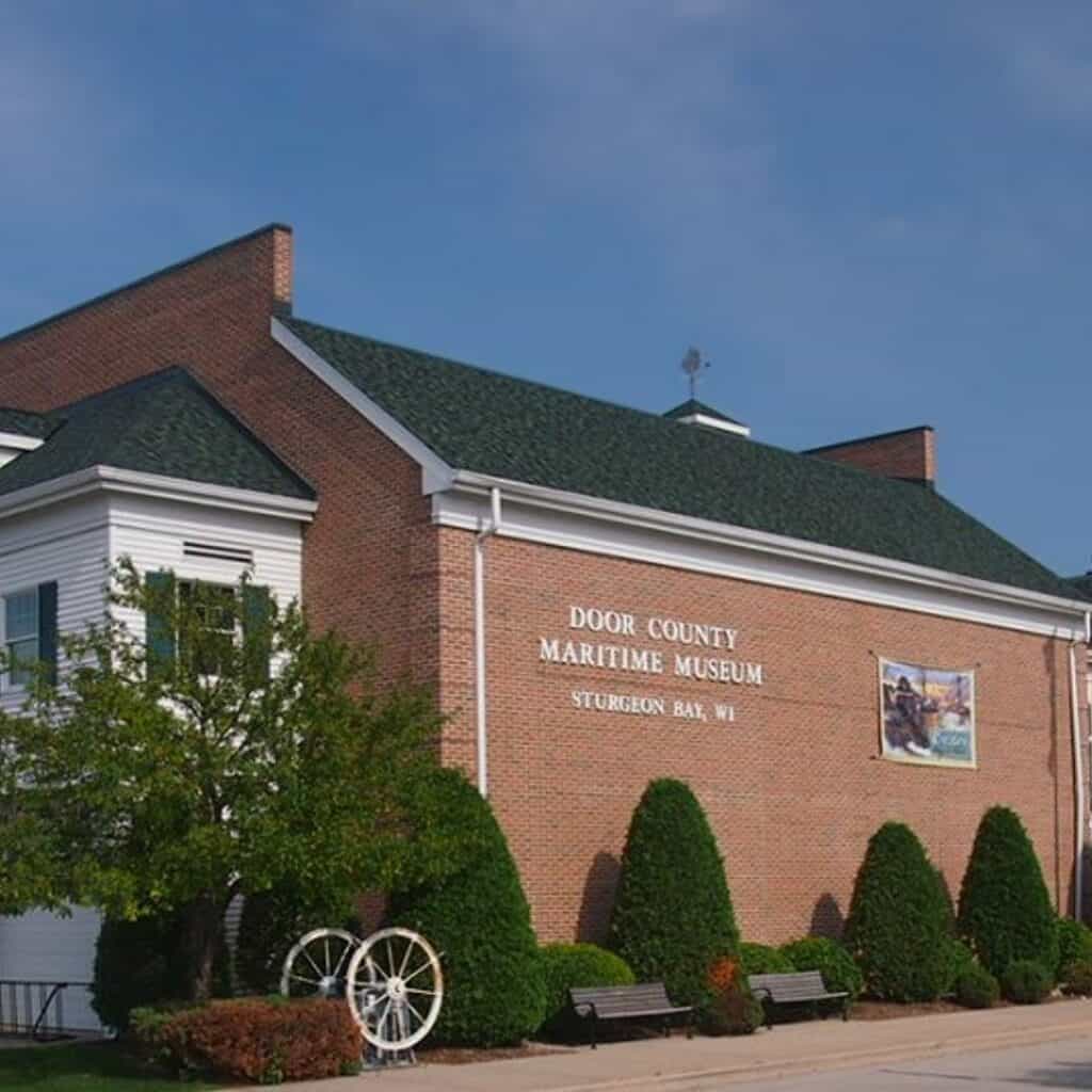a large brick building with a sign on the front of it and trees on the wall